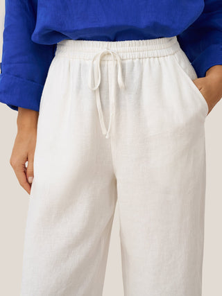 Light-colored linen classic pants by Lintico, featuring a relaxed fit and tailored waistband, perfect for casual or smart occasions.