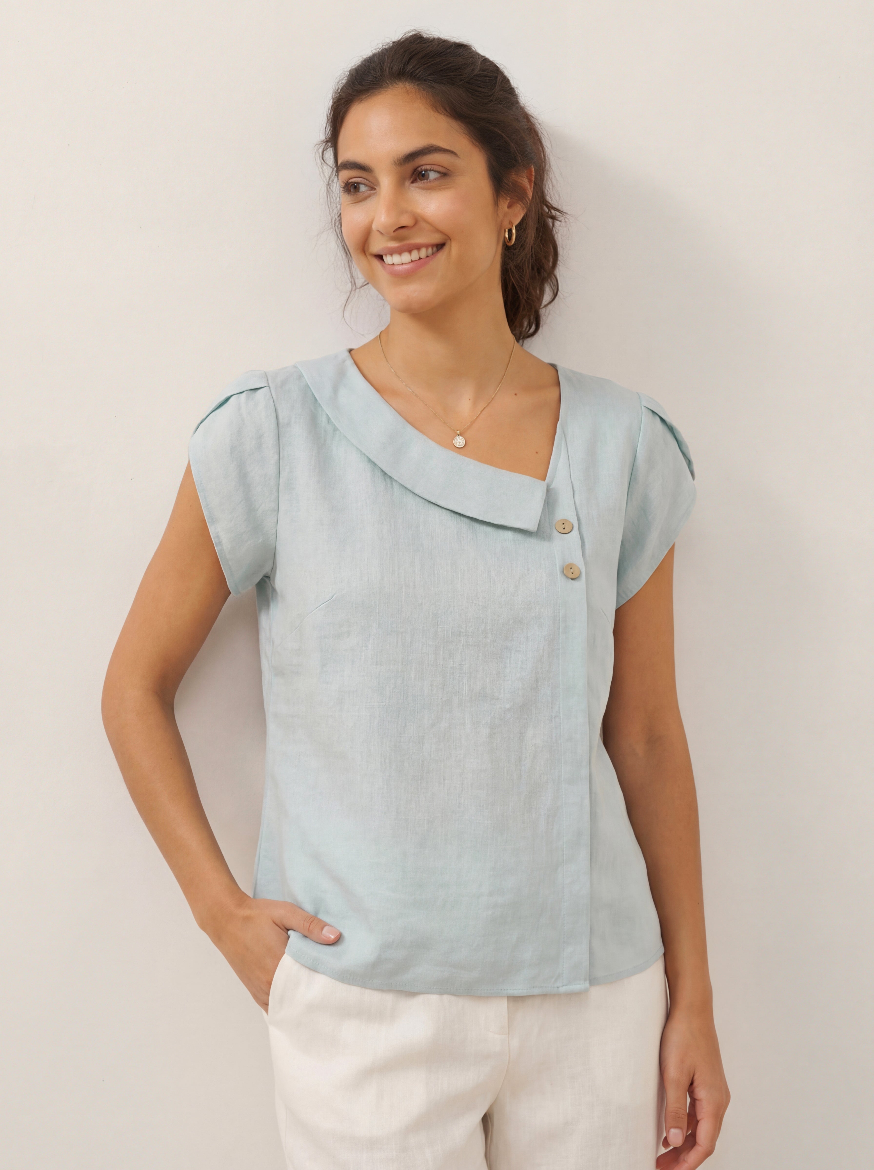 Aqua blue linen blouse with a crescent collar and flutter sleeves from LINTICO, styled as a casual, lightweight top.