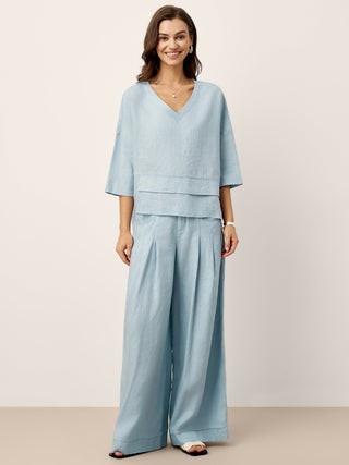 Sky blue linen drop shoulder top with asymmetric layered hem by LINTICO, featuring a relaxed fit and casual style.
