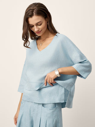 Sky blue linen drop shoulder top with asymmetric layered hem by LINTICO, featuring relaxed fit and casual style.