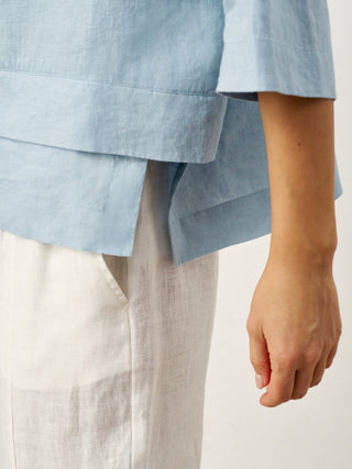 Sky blue linen drop shoulder top with asymmetric layered hem from LINTICO, casual and stylish layered shirt for women.