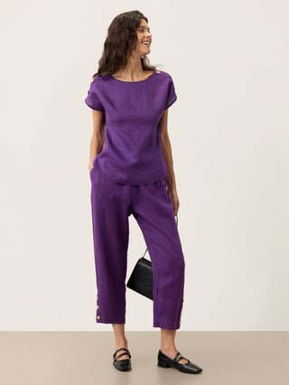 Dark purple linen tapered pants with artisan button detail from LINTICO's Katherine collection, showcasing a stylish, comfortable bottom.