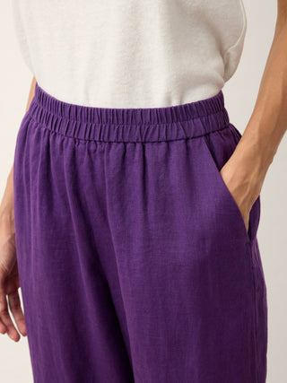 Dark purple 100% linen artisan tapered pants by LINTICO, featuring button details and a relaxed fit.