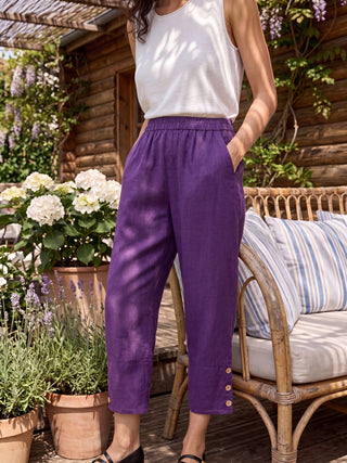Dark purple linen tapered pants with artisan buttons from LINTICO's Katherine collection, showcasing a stylish, relaxed fit.