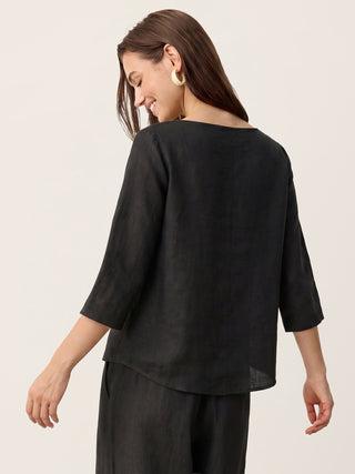 LINTICO 100% linen asymmetric-hem button-trim top in charcoal black, shown on a model with a relaxed fit.