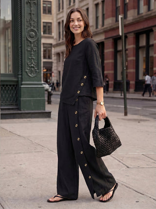 Charcoal black linen top with asymmetric hem and button trim from LINTICO, featuring a relaxed fit and stylish design.