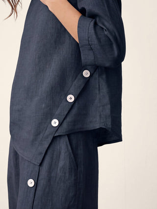 Navy blue linen top with asymmetric hem and button trim by LINTICO, featuring a stylish, relaxed fit and natural fabric texture.