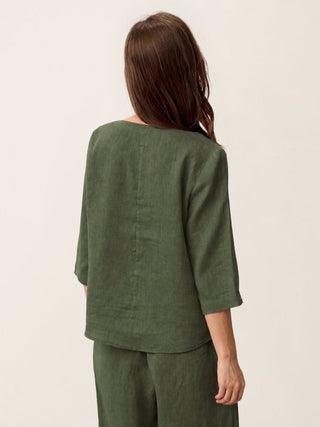 Forest olive linen top by LINTICO featuring an asymmetric hem and button trim, with a stylish, relaxed fit.