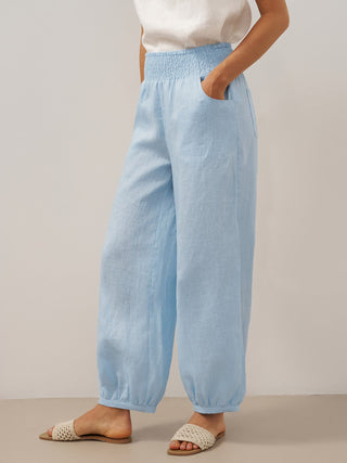 Light blue linen pants with a broad elastic waistband, designed by LINTICO, featuring a relaxed fit and comfortable style.