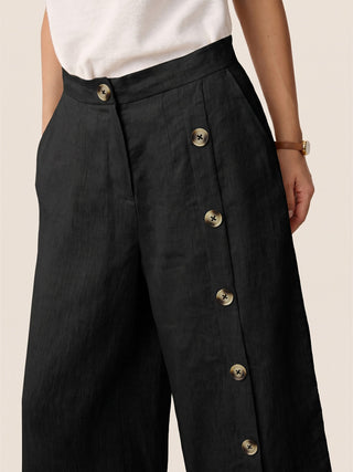 LINTICO charcoal black linen bottoms with buttoned slit-hem pants, featuring a relaxed fit and stylish design.