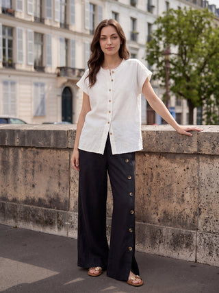 LINTICO Katya charcoal black linen pants with buttoned slit hem, relaxed fit, and tailored design, showcased on a model.
