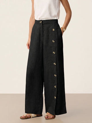 Charcoal black linen pants with buttoned slit hem from LINTICO's KATYA collection, featuring a relaxed fit and stylish design.