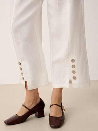 Optic white linen split-hem pants with button details from LINTICO's ALINA collection, showcasing relaxed, breathable bottoms.
