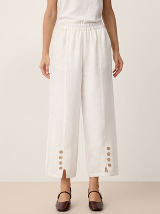 Optic white linen pants with buttoned split hems by LINTICO, featuring a relaxed fit and casual style.
