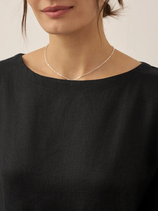 LINTICO Valencia 100% linen A-line midi dress displayed on a hanger, showcasing its flowy fabric and simple elegant design.