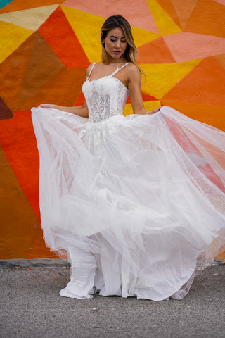 Lara New York Lara 51042 white sheer lace bridal ballgown dress with fitted bodice and flowing skirt on a model.