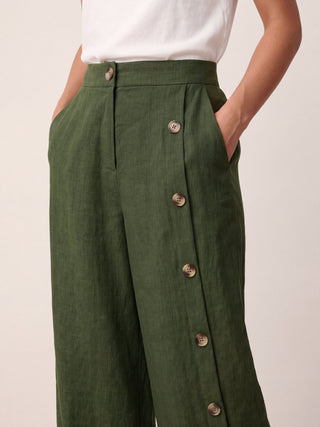 LINTICO linen buttoned slit-hem pants with a relaxed fit, featuring a natural fabric texture and side pockets.