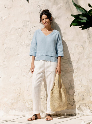 Sky blue linen drop shoulder top with asymmetric layered hem from LINTICO, casual and stylish layered shirt for women.