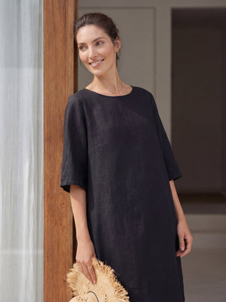 Charcoal black linen collarless mid-length dress by LINTICO, featuring a relaxed fit and elegant design.