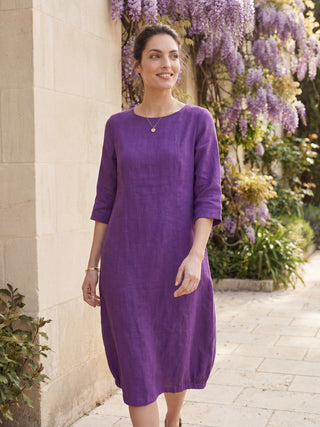 Dark purple linen midi dress with collarless design from LINTICO's Sofia collection, featuring a mid-length, relaxed fit.