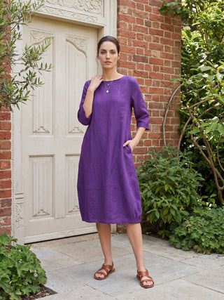 Dark purple linen mid-length dress with a collarless design by LINTICO, perfect for casual or elegant occasions.