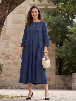 Navy blue linen maxi dress with bateau neckline and pleated design by LINTICO, featuring a flowing, elegant silhouette.