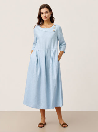 Baby blue linen maxi dress with crescent neck, decorative buttons, and pleated waist from LINTICO's Gwenyth collection.