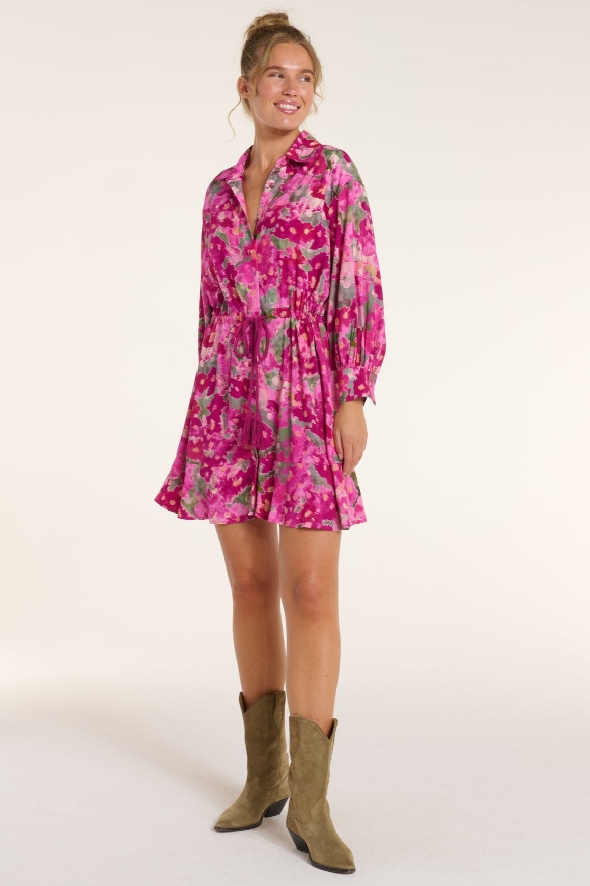 Rebecca Collared Tie Mini Dress in Pink Floral Ikat paired with western boots, highlighting its playful silhouette and bold floral pattern.
