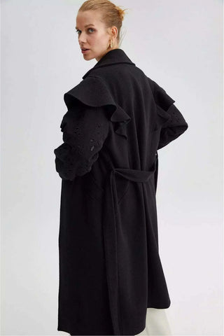 Black lace detailed coat with belt from By Baano, stylish outerwear with intricate lace accents and a waist belt.