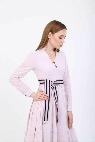 BY Baano Elise V-neckline midi dress in summer fabric with a belt, displayed on a hanger with a floral background.