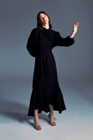 Black Mia midi dress for women by ByBaano, shown on a model with a fitted waist and flowing skirt.