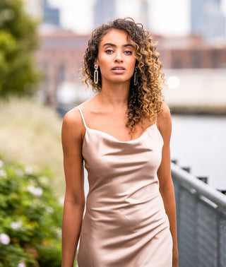 Lady Black Tie Aspen Midi Dress in champagne satin slip style, elegant and flowing with a sleek, shiny fabric.